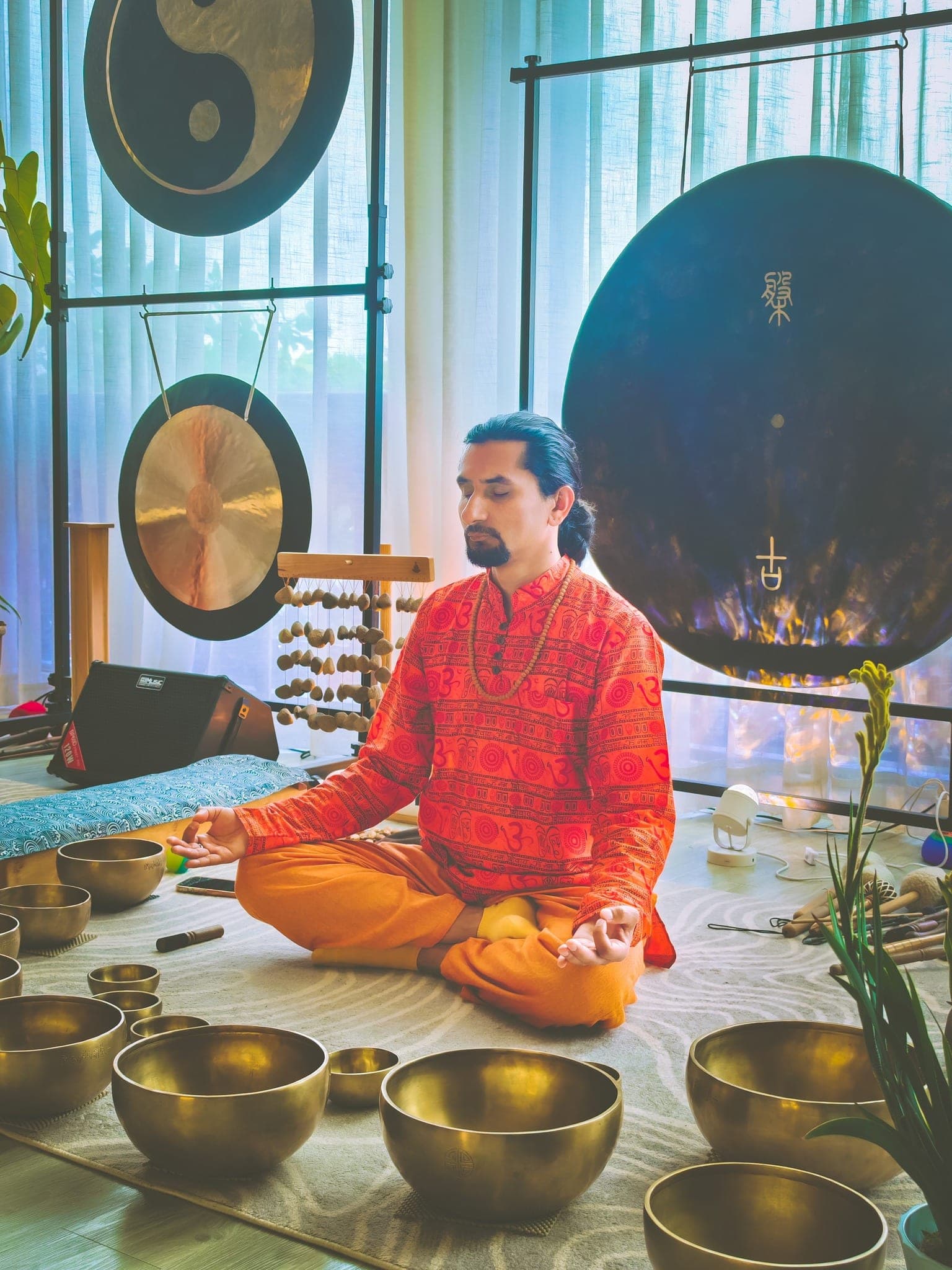 Grand Master Akash Banjara seated in meditation, surrounded by Himalayan singing bowls