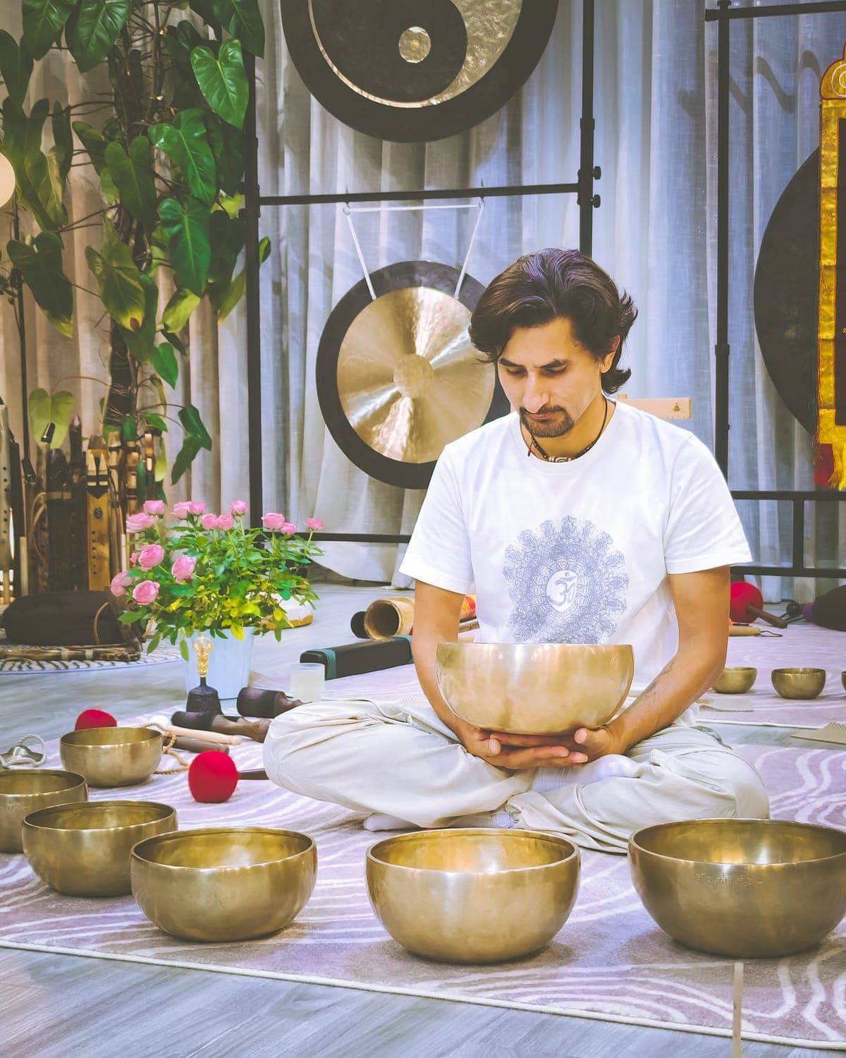 A practitioner giving an individual sound healing treatment with a singing bowl